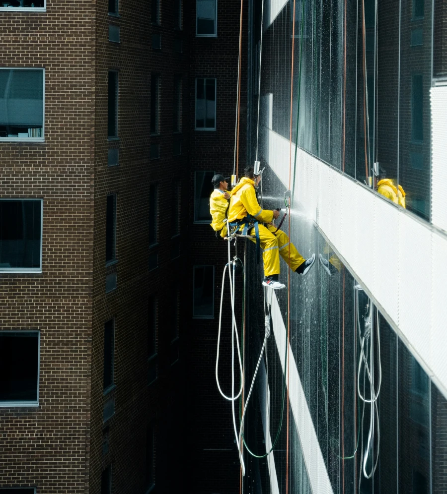 Rope access teknikere sprayer bygning facade sommer